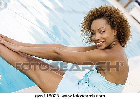 Portrait of a young woman smiling at the poolside View Large Photo Image Stock Photo - Portrait of a young woman smiling at the poolside. Fotosearch