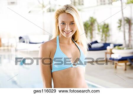 Portrait of a young woman standing at the poolside View Large Photo Image Stock Photo - Portrait of a young woman standing at the poolside. Fotosearch