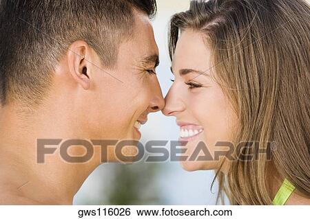 Side profile of a young couple rubbing their noses View Large Photo Image Stock Photograph - Side profile of a young couple rubbing their noses. Fotosearch