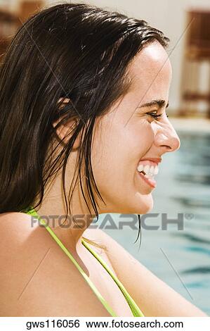 Side profile of a young woman smiling in a swimming pool View Large Photo Image Stock Photograph - Side profile of a young woman smiling in a swimming pool. Fotosearch