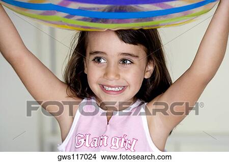 Close-up of a girl carrying an inflatable ball over her head View Large Photo Image Picture - Close-up of a girl carrying an inflatable ball over her head. Fotosearch