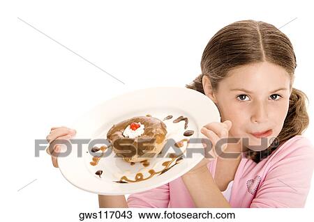 High angle view of a girl holding a donut in a plate licking her lips View Large Photo Image Stock Image - High angle view of a girl holding a donut in a plate licking her lips. Fotosearch