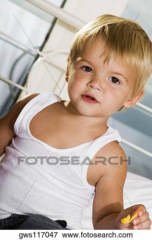 Portrait of a boy holding a rose petal View Large Photo Image Stock Photo - Portrait of a boy holding a rose petal. Fotosearch