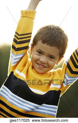 Stock Photography - Portrait of a boy smiling with his arms raised. Fotosearch