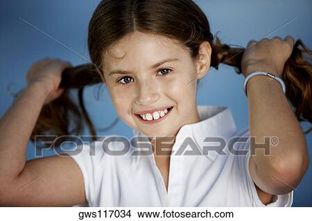 Portrait of a girl pulling her pigtails View Large Photo Image Picture - Portrait of a girl pulling her pigtails. Fotosearch