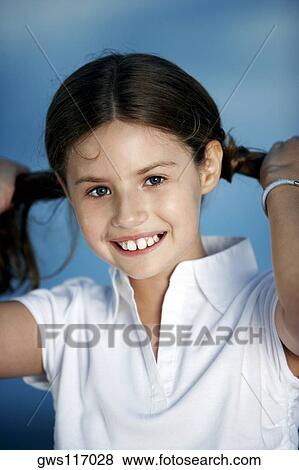 Stock Photo - Portrait of a girl pulling her pigtails. Fotosearch