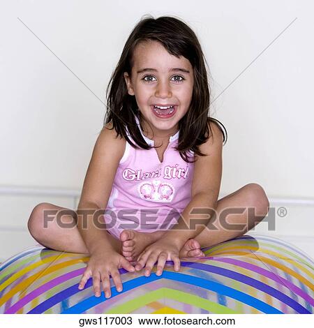 Portrait of a girl sitting on an inflatable ball View Large Photo Image Stock Image - Portrait of a girl sitting on an inflatable ball. Fotosearch