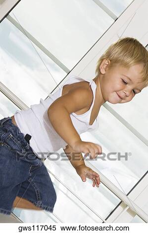 Stock Photography - Side profile of a boy jumping on the bed. Fotosearch