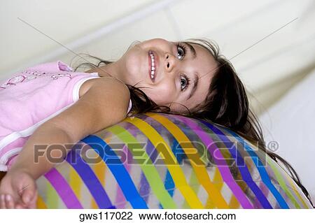 Side profile of a girl lying on an inflatable ball View Large Photo Image Stock Image - Side profile of a girl lying on an inflatable ball. Fotosearch
