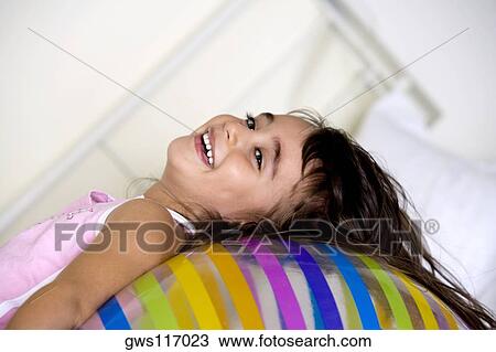 Stock Image - Side profile of a girl lying on an inflatable ball. Fotosearch