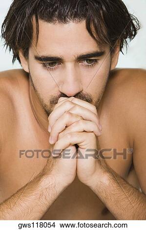 Close-up of a young man looking pensive View Large Photo Image Picture - Close-up of a young man looking pensive. Fotosearch