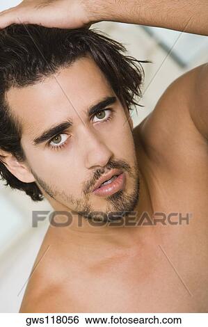 Portrait of a young man with his hand on his head View Large Photo Image Stock Photograph - Portrait of a young man with his hand on his head. Fotosearch