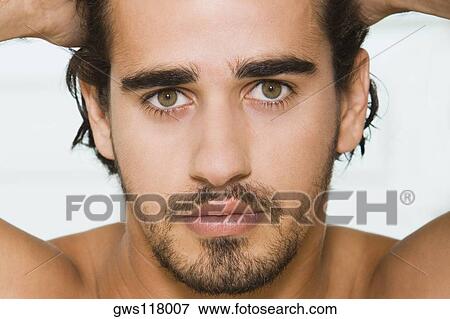 Portrait of a young man with his hands on his head View Large Photo Image Stock Photo - Portrait of a young man with his hands on his head. Fotosearch