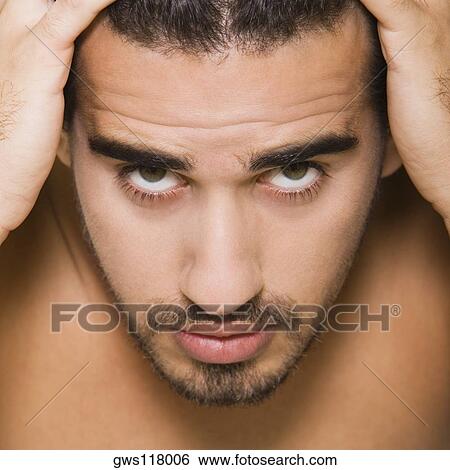 Portrait of a young man with his hands on his head View Large Photo Image Stock Photograph - Portrait of a young man with his hands on his head. Fotosearch
