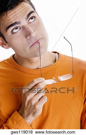 Close-up of a mid adult man holding a pair of eyeglasses View Large Photo Image Stock Photo - Close-up of a mid adult man holding a pair of eyeglasses. Fotosearch