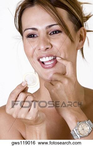 Stock Photograph - Close-up of a mid adult woman holding a condom. Fotosearch