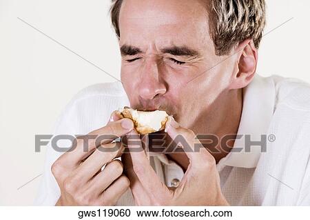 Close-up of a young man eating a strawberry tart View Large Photo Image Stock Image - Close-up of a young man eating a strawberry tart. Fotosearch