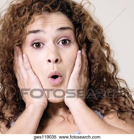 Close-up of a young woman with her hands on her face View Large Photo Image Stock Photography - Close-up of a young woman with her hands on her face. Fotosearch