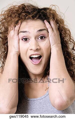 Close-up of a young woman with her hands in her hair View Large Photo Image Stock Photography - Close-up of a young woman with her hands in her hair. Fotosearch
