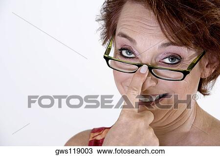Portrait of a senior woman adjusting her eyeglasses View Large Photo Image Stock Image - Portrait of a senior woman adjusting her eyeglasses. Fotosearch