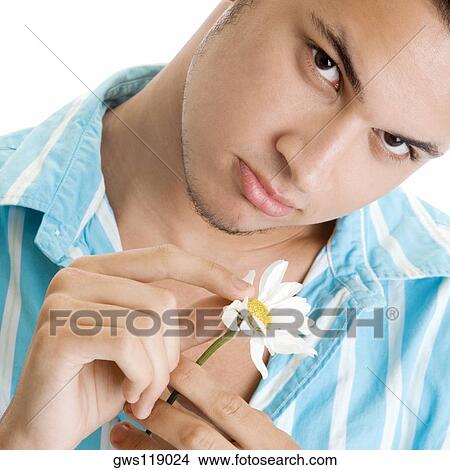Portrait of a young man holding a flower View Large Photo Image Picture - Portrait of a young man holding a flower. Fotosearch