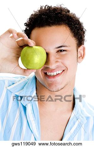 Portrait of a young man holding an apple View Large Photo Image Stock Photo - Portrait of a young man holding an apple. Fotosearch