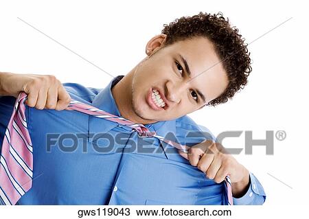 Portrait of a young man pulling his tie View Large Photo Image Stock Image - Portrait of a young man pulling his tie. Fotosearch