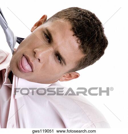 Portrait of a young man pulling his tie View Large Photo Image Stock Image - Portrait of a young man pulling his tie. Fotosearch