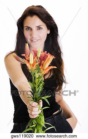 Portrait of a young woman holding a bunch of flowers View Large Photo Image Stock Image - Portrait of a young woman holding a bunch of flowers. Fotosearch