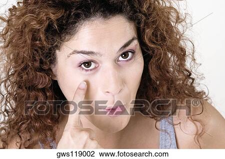 Portrait of a young woman pointing at her eye View Large Photo Image Stock Image - Portrait of a young woman pointing at her eye. Fotosearch