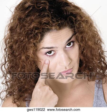 Portrait of a young woman pointing at her eye View Large Photo Image Stock Image - Portrait of a young woman pointing at her eye. Fotosearch