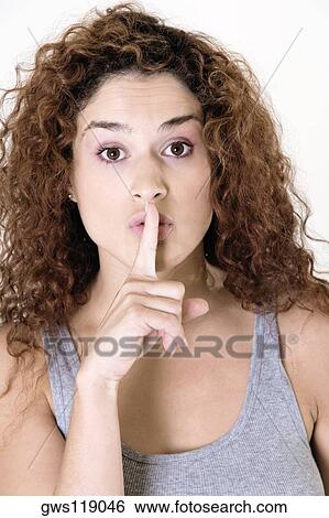 Portrait of a young woman with her finger on her lips View Large Photo Image Stock Photograph - Portrait of a young woman with her finger on her lips. Fotosearch