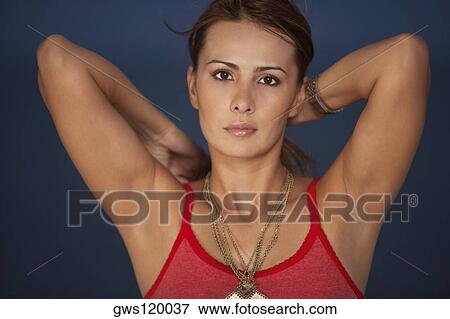 Stock Photo - Portrait of a mid adult woman with her hands behind her head. Fotosearch