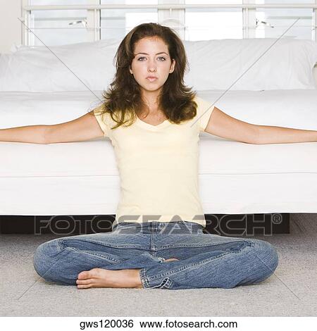 Portrait of a young woman leaning against a bed View Large Photo Image Stock Photograph - Portrait of a young woman leaning against a bed. Fotosearch