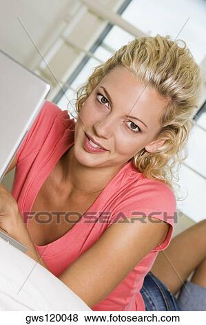 Portrait of a young woman lying in front of a laptop View Large Photo Image Stock Photo - Portrait of a young woman lying in front of a laptop. Fotosearch