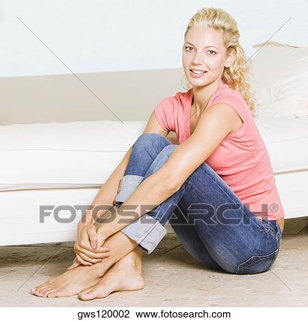 Portrait of a young woman sitting on the floor View Large Photo Image Stock Image - Portrait of a young woman sitting on the floor. Fotosearch