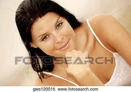 Portrait of a young woman smiling with her hand on her chin View Large Photo Image Stock Photography - Portrait of a young woman smiling with her hand on her chin. Fotosearch