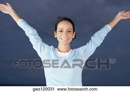 Stock Image - Portrait of a young woman with her arms outstretched. Fotosearch