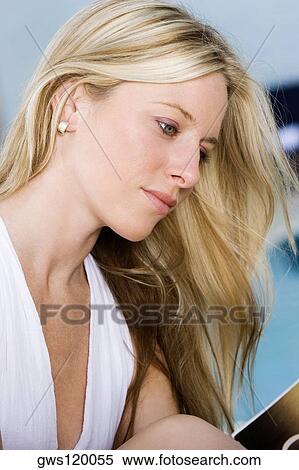Stock Photography - Side profile of a young woman reading a book. Fotosearch