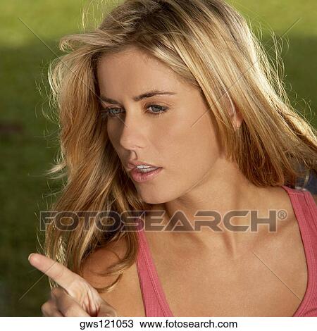 Close-up of a young woman pointing forward View Large Photo Image Stock Image - Close-up of a young woman pointing forward. Fotosearch