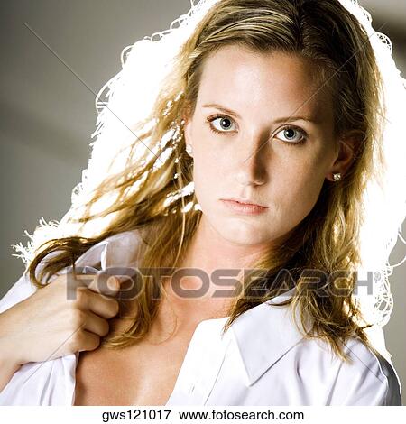 Portrait of a young woman holding her shirt collar View Large Photo Image Stock Photo - Portrait of a young woman holding her shirt collar. Fotosearch
