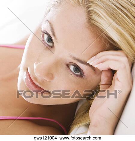 Portrait of a young woman lying on the bed View Large Photo Image Picture - Portrait of a young woman lying on the bed. Fotosearch