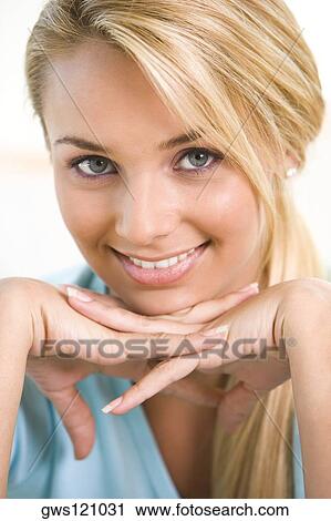Portrait of a young woman smiling with her hand on her chin View Large Photo Image Stock Image - Portrait of a young woman smiling with her hand on her chin. Fotosearch