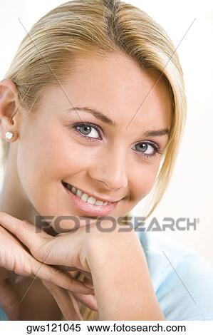 Portrait of a young woman smiling with her hand on her chin View Large Photo Image Stock Photography - Portrait of a young woman smiling with her hand on her chin. Fotosearch