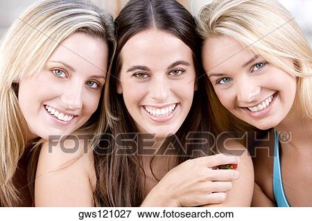 Stock Photo - Portrait of three young women smiling. Fotosearch