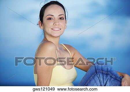 Side profile of a young woman smiling View Large Photo Image Stock Photo - Side profile of a young woman smiling. Fotosearch