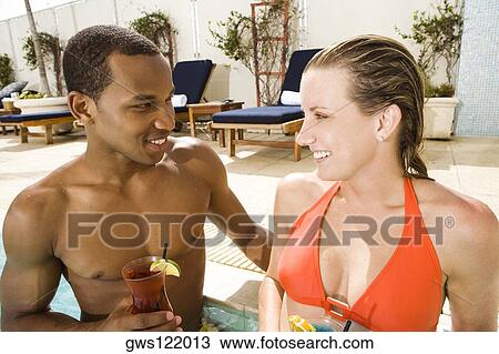 Close-up of a young couple looking at each other in a swimming pool View Large Photo Image Stock Image - Close-up of a young couple looking at each other in a swimming pool. Fotosearch