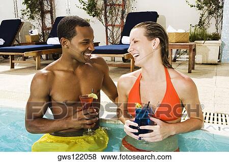 Close-up of a young couple looking at each other in a swimming pool View Large Photo Image Stock Photo - Close-up of a young couple looking at each other in a swimming pool. Fotosearch