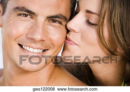 Stock Photo - Close-up of a young woman kissing a young man. Fotosearch
