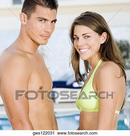 Portrait of a young couple standing at the poolside View Large Photo Image Stock Image - Portrait of a young couple standing at the poolside. Fotosearch